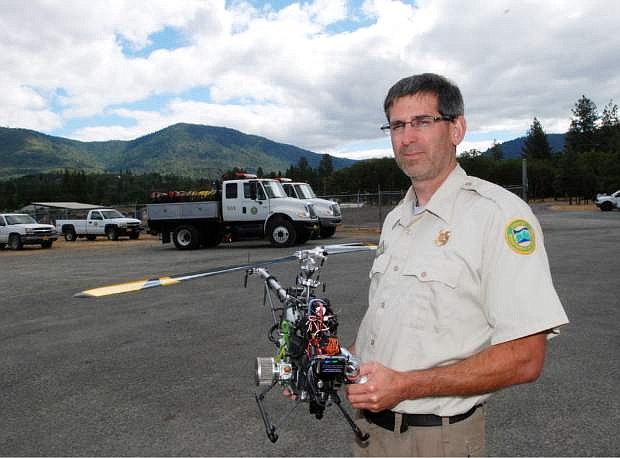 Tyson Shultz of the Oregon Department of Forestry poses June 17, 2014 with a radio-controlled helicopter at the department&#039;s compound on the outskirts of Grants Pass, Ore. The department is equipping the aircraft with video and infrared cameras and a GPS locator. It plans to use the helicopter this summer as another set of eyes on wildfires. With privacy concerns dampening the enthusiasm over drones, Oregon is ahead of the curve in actually buying its own aircraft. The nation&#039;s biggest wildfire agency, the U.S. Forest Service, has been working with NASA drones since 2007, but is not expected to come out with a decision on how to use them until next year. (AP Photo/Jeff Barnard)