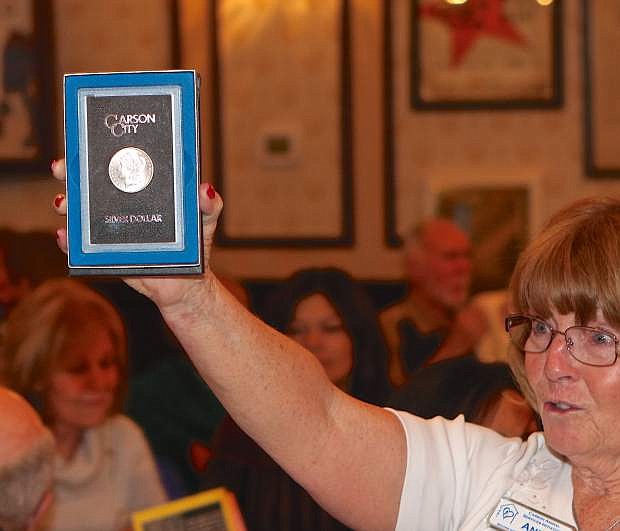 A Carson City commemorative silver dollar is held up by volunteer Anita Habberfield and eventually fetches $600 during the CASI auction Friday.
