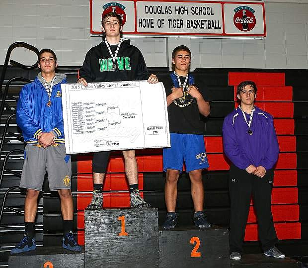 Fallon&#039;s David Hughes, with sign, stands atop the podium after winning the 170-pound class at the Carson Valley Lions Invitational on Saturday in Minden.