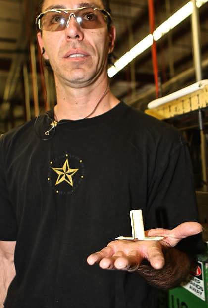 Jeremiah Cook holds a composite stand-off, a part used on Boeing, Airbus and Gulfstream aircraft.