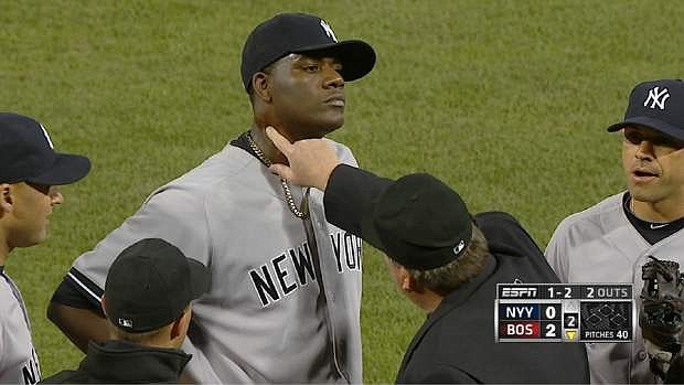 In this  photo taken from video and provided by ESPN, home plate umpire Gerry Davis checks the neck of Yankees starting pitcher Michael Pineda. He was ejected.