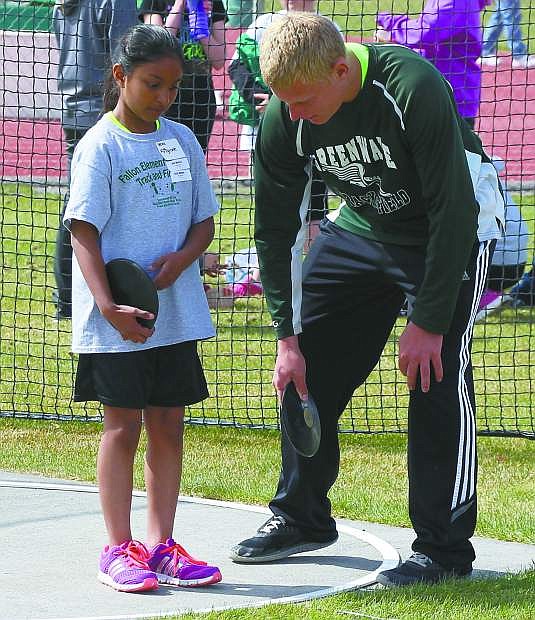 Fifth-grader Vera Vaz goes over the fundamentals for the discus with Fallon varsity track athlete Carson Rigney.