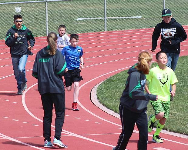 Steven Moon, green shirt, leads the pack duirng the 1,600-meter race as Parker Steele, blue shirt, and Everdmar Garcia are supported by members of the Fallon track team during Wednesday&#039;s meet.