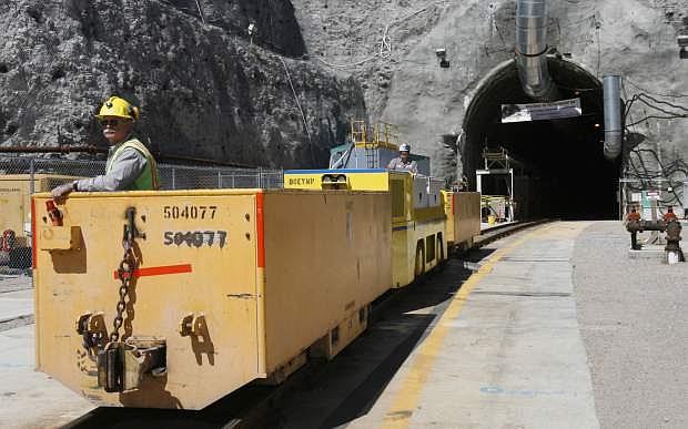 FILE - In this April 13, 2006 file photo, Pete Vavricka conducts an underground train from the entrance of Yucca Mountain in Nevada. Federal nuclear regulators say the U.S. Energy Department will need to acquire water rights and a land buffer before it can entomb the nation&#039;s radioactive waste beneath a long-studied volcanic ridge in the Nevada desert. The Nuclear Regulatory Commission issued a report Thursday, Dec. 18, 2014, saying most administrative and program elements of the Yucca Mountain repository meet commission requirements.  (AP Photo/Isaac Brekken, File)