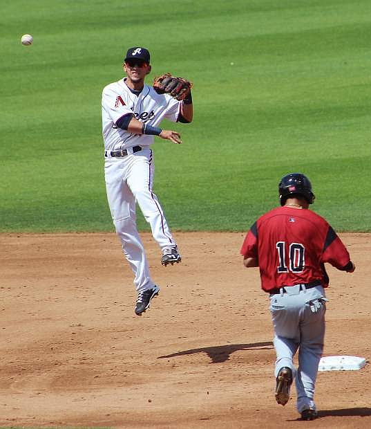 Reno Aces shortstop Jack Reinheimer leaps high to make his throw in a double play attempt against Sacramento on Sunday at GreaEtr Nevada Field.