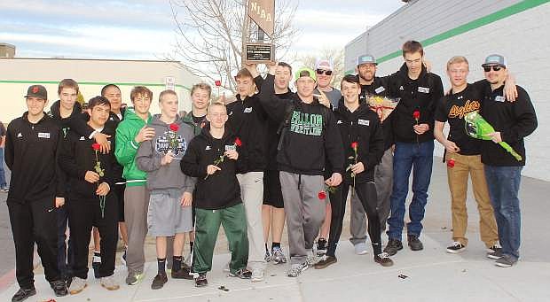 Upon their arrival in Fallon on Sunday, team members display the state wrestling trophy for fans, friends and family.