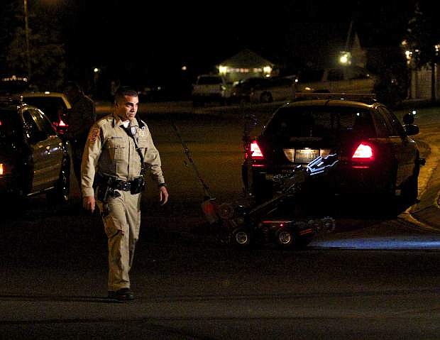 A DCSO officer walks back with the robot that was sent in to the house on Edlesborough Circle during a standoff in Gardnerville Tuesday night.