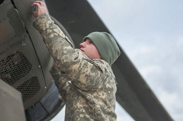 A soldier from Det. 1 B Company 1-189th works to prepare a Chinook helicopter for flight Jan. 10 2015 in order to execute what soldiers believed was a real world rescue mission. The exercise was a drill in order to test the units&#039; emergency preparedness.