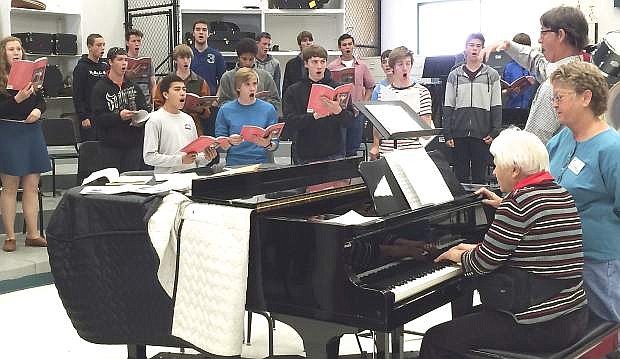 Churchill County music teacher Tom Fleming practices with his students during music class with the help from Margot Mills, seated, and Cydne Craig a substitute aide, standing.