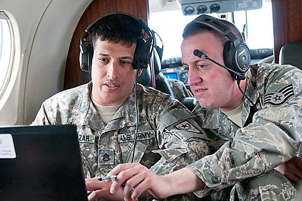 Staff Sgt. Jon Cumings, right, an analyst with the 152nd Intelligence Squadron, discusses imagery system operations with Staff Sgt. Michael Salazar of Detachment 45, Operational Support Airlift, during joint training over Pyramid Lake on May 9. Several 152nd Airmen are set to train with Det 45 soldiers for several weeks as the Army unit prepares for its deployment to Afghanistan.