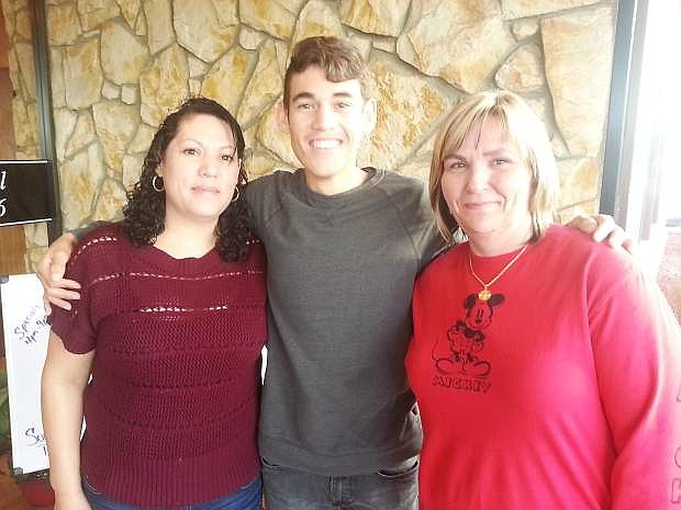 Miguel Angel Perez, center, is surrounded by his mother Juana, on left, and his aunt Robin Anaya, right. Miguel is fighting a kidney disease which requires frequent travel to doctor appointments, and the optimistic hope of a trip for a kidney transplant. Robin Anaya is organizing a yard sale fundraiser and tamale bake on Nov. 21 at Farmers Insurance Agency, 710 W. Williams Ave.