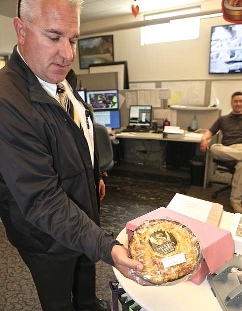 Carson City Detective David LeGros delivers a coffee cake to the dispatch center in Carson City Wednesday.