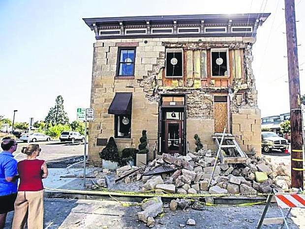 Pedestrians stop to examine a crumbling facade at the Vintner&#039;s Collective tasting room in Napa, Calif., after an earthquake on Sunday.
