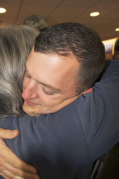 A family friend gives Staff Sgt. Nicholas Scobert a hug after he arrived in Reno.