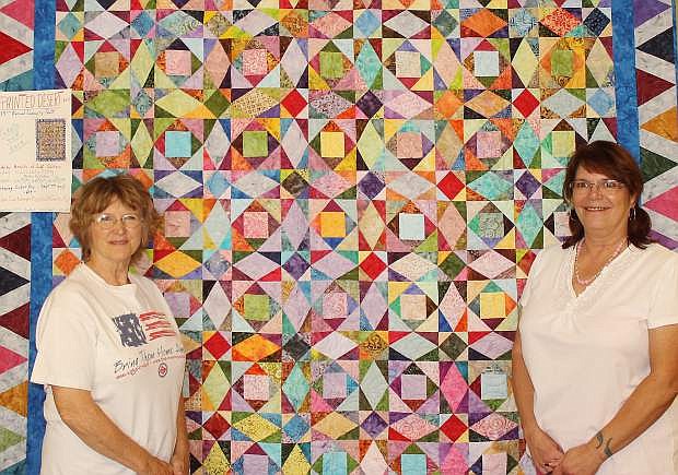 Vicky Eckert, left, and Rory Litch display a quilt that will be raffled on Monday during the final day of the Fallon Cantaloupe Festival and Country Fair. This is the 13th year for raffling a community quilt by the Hearts of Gold quilters. The quilt, Painted Desert, is the work of Kathy Valladon.