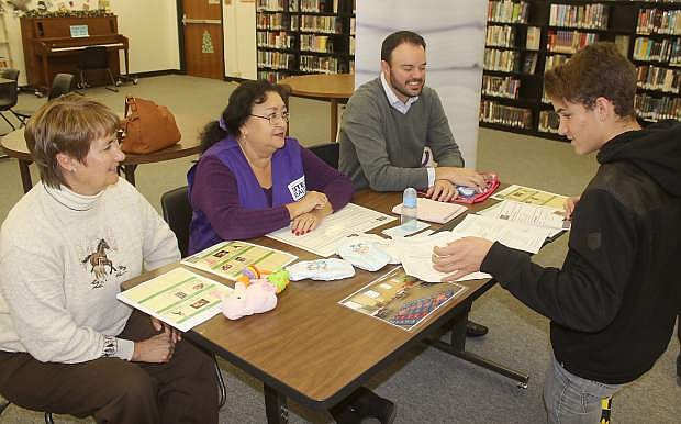 Dana Endacott, left, Loretta Serna of Berney Realty and Nick Serrano of Greater Nevada Mortgage and Credit Union assist Shane Horton with his budgeting.