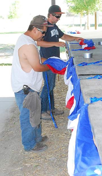 Brit Edralin, left, and Tyson Ernst place bunting on the stage Thursday at the Churchill County Fairgrounds in preparation to Picnic in the Park on the Fourth of July.