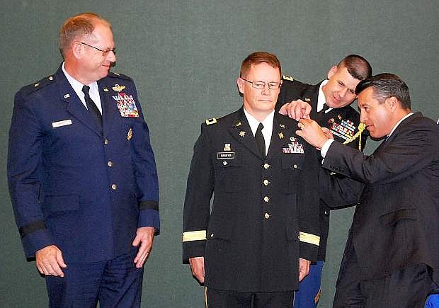 Gov. Brian Sandoval, right, and Chief Warrant Officer 2 Joe Sherych change on Friday one of the shoulder boards on Brig. Gen. Michael Hanifan&#039;s uniform. Looking on is Brig. Gen. William Burks,Nevada&#039;s adjutant general. Hanifan was promoted from colonel to brigadier general in a ceremony at the capitol&#039;s Guinn Room.