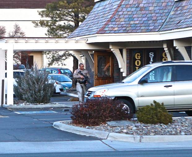 A DCSO officer with an assault rifle surveys the scene at the Gold and Silver store in Gardnerville Thursday.