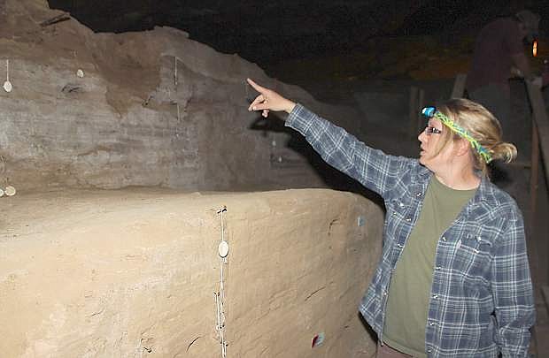 Archaeologist Christine Bowen shows an area where workers removed graffiti last spring.