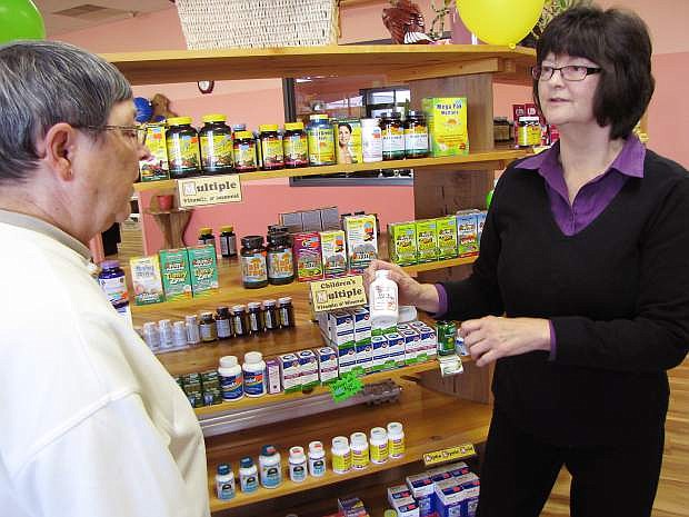 Angel Marcellus, right, owner of Country Health, discusses a supplement with customer Louise Davis. The store will close Saturday.