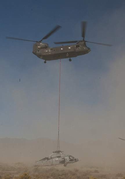 A Nevada Guard 1/189th Aviation Chinook helicopter lifts a Navy Knight Hawk off the Dixie Valley floor on Thursday. The Navy helicopter crashed during a routine training mission Sept. 2.