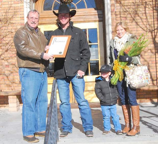 Fallon Mayor Ken Tedford Jr., left, presents a proclamation to Jade Corkill, who, with his partner, won the world team roping championship at the National Finals Rodeo. Also pictured are 3-year-old Caleb and Haley Corkill.