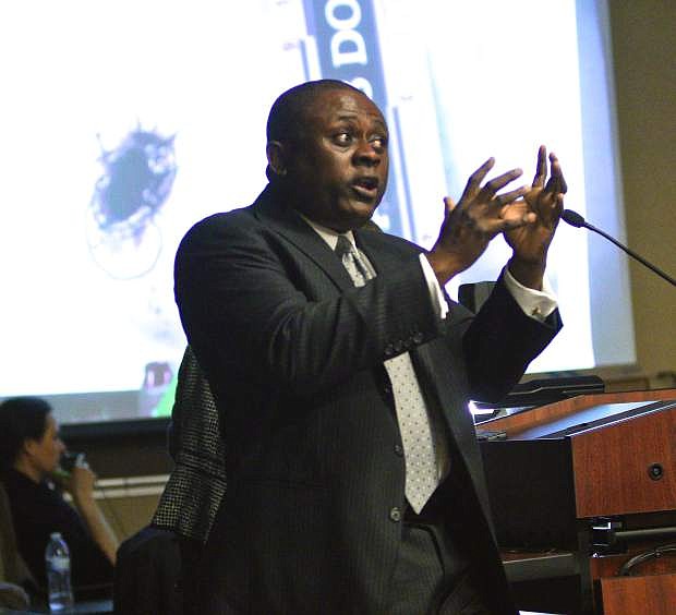 Dr. Bennet Omalu, forensic pathologist and witness for the defense, explains to the jury how Harry Leibel could have taken his own life as shown by photographic evidence behind him Wednesday in Gardnerville.