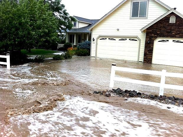 Flood waters rush around a home last summer in the Carson Valley during the floods.