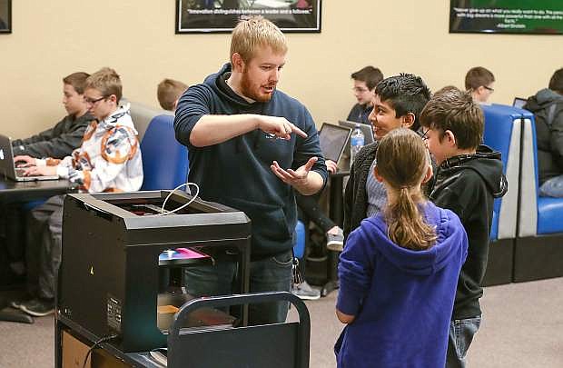 Library Assistant Aubrey White talks to teens, from left, Anu Praveen, Seth Taylor and Jessica Artz about using the 3D printer during a Habits of Mind(craft) workshop at the Carson City Library on Saturday. The library hosts two Saturday workshops each month where students use Mindcraft as a fun platform to apply science, technology, engineering, artistic and math skills.