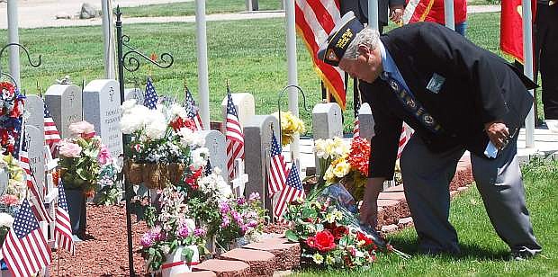 Pat LeClaire places flowers at The Gardens Veterans Cemetery during Memorial Day ceremonies in 2014.
