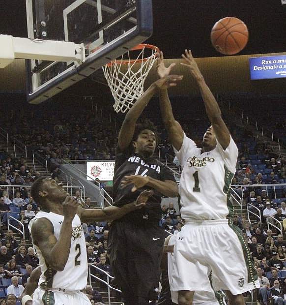 The Wolf Pack&#039;s Lindsey Drew (14) rejects CSU&#039;s Antwan Scott&#039;s shot, while his Rams&#039; teammate Emmanuel Omogbo watches.