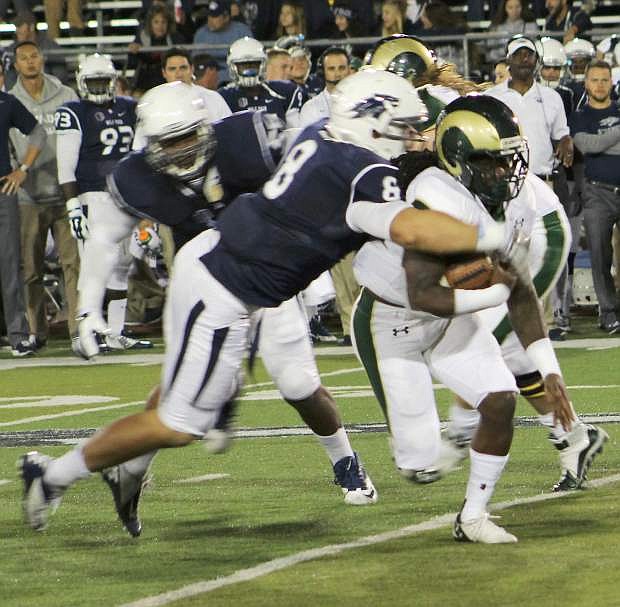 Nevada defensive end Ian Seau wraps up Colorado State University running back Dee Hart for little gain.