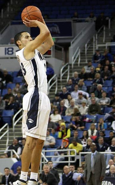 Nevada guard Michael Perez hits a jumper with head coach David Carter looking on in the Wolf Pack&#039;s 80-72 win over Iona on Sunday at Lawlor Events Center.