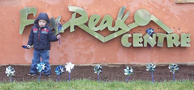 Wyatt Miller holds a pinwheel before planting it in front of the Fox Peak sign during the 2015 event..
