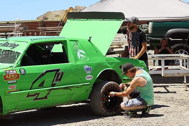 Hobby Stock racer Chris Christiano, left, and his crew chief, Andrew Cobb, work on Christiano&#039;s car before racing.