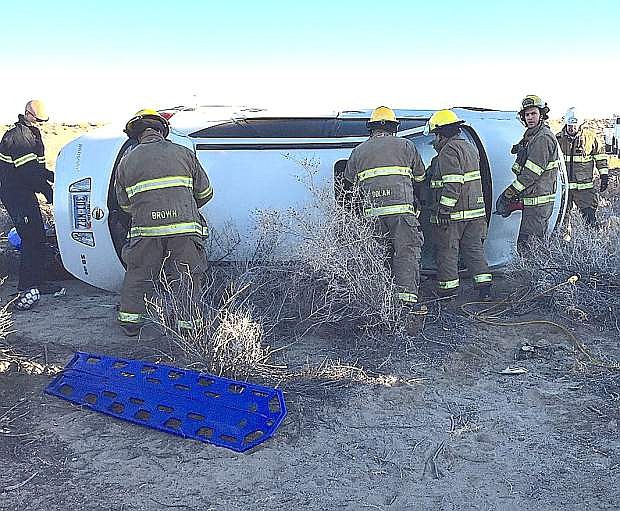 Firemen from the Fallon/Churchill Fire Department work to remove an injured Silver Springs woman from a vehicle that rolled over Monday morning on Soda Lake Drive.