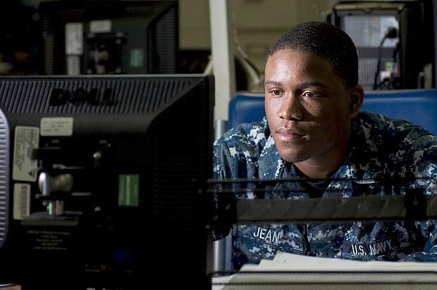 Personnel Specialist Seaman Fanes Jean, assigned to the Administration Department aboard the Nimitz-class aircraft carrier USS Carl Vinson (CVN 70), processes separation packages in the personnel office.
