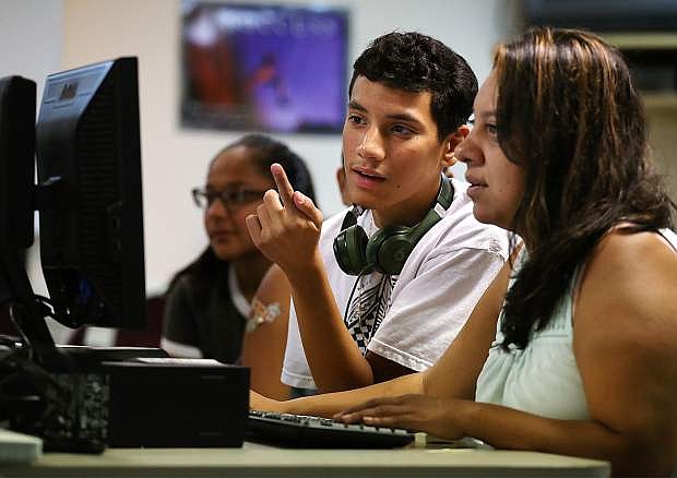 Maria Beltran helps her son Ricardo Haro, 17, register online for classes at the Carson High School in Carson City, Nev., on Thursday, Aug. 18, 2016. The Carson City School District switched to Infinite Campus, a student information system that allows the state to better track student information.