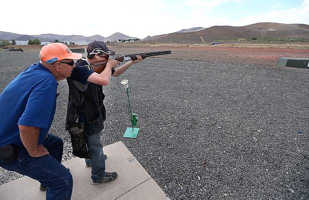 Coach Rusty Wolbers works with Robert Lamkin, 13, during practice at the Capitol City Gun Club, in Carson City, Nev., on Friday, July 11, 2014. This year&#039;s Youth Shotgun Championships will be held Saturday at the club from 8-4 p.m.