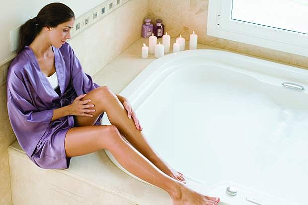 A woman who is taking care of her skin sits near the bath.