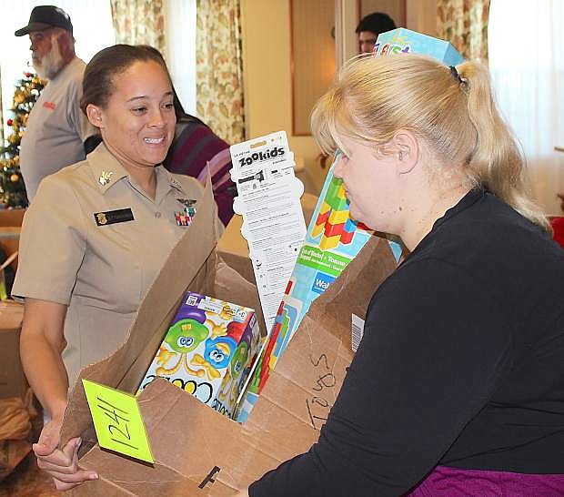 AZ1 Celia Crackovich, left, gives a box of toys to Maime Hutchinson at the Toys for Tots distribution on Friday.