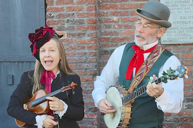 Pamela Kather and Gordy Oligher play traditional Christmas songs and hymns from their sidewalk location at Nevada City&#039;s Victorian Christmas.