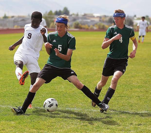 :Fallon junior Nick Kulick (5) blocks a shot by Elko senior Richard Adomako. Fallon senior Thomas Robertson (4) looks on. ROSS ANDERSON / EDFP