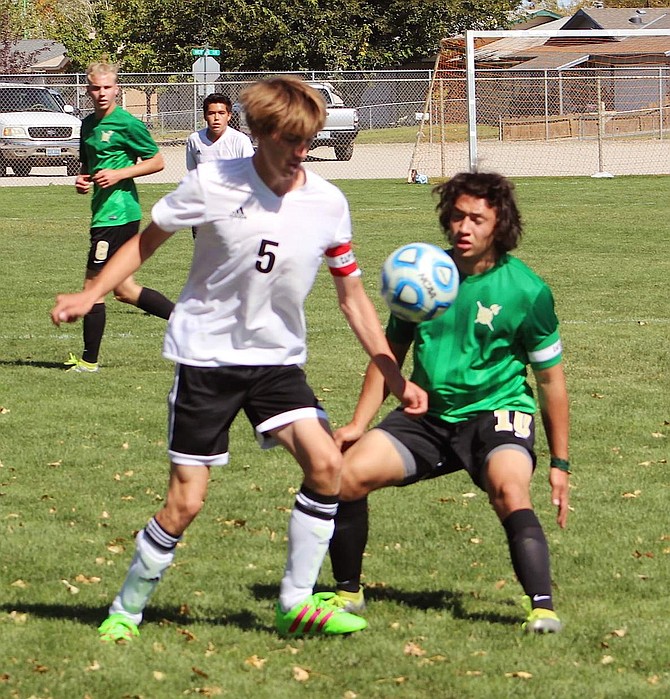 Fallon soccer player Nick Kulick (5) and an Incline player fight for ball control in Saturday&#039;s match.