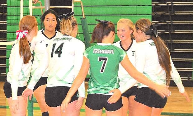 The Lady Wave varsity volleyball team celebrates after a successful serve.