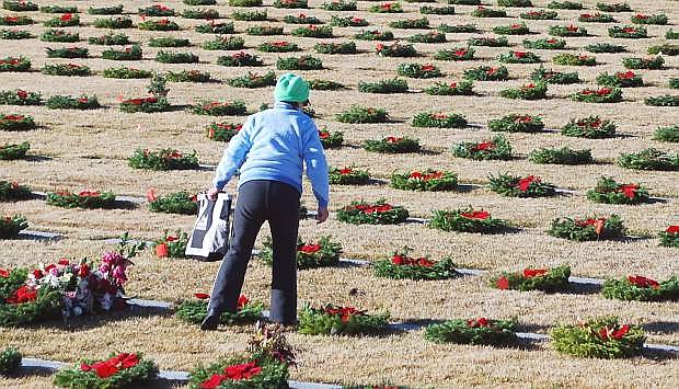 A woman places a wreath at the graaesite of a loved one at the 2014 &quot;Wreaths Across America&quot; program at the Northern Nevada Veterans Memorial Cemetery at Fernley.