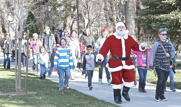 Santa walks along the capital mall with a good sized group of people on their way to the Carsom Mall Saturday in Carson City.