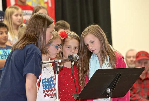 Eleanor Romeo, Leea Waterman, Addysen Davis and Camryn Peachay read about the history of Veterans Day during an assembly at Fritsch Elementary Thursday.