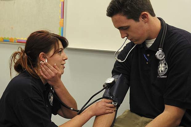 Lisa Stokes, 21, of Carson City, takes the blood pressure of fellow student Matt Santos, 18, of Minden, during an Emergency Medical Technician class at Western Nevada College on April 9, 2015.